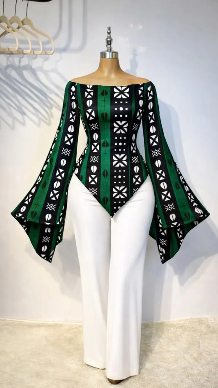 Green and black mudcloth-print off-shoulder top with bell sleeves over white trousers