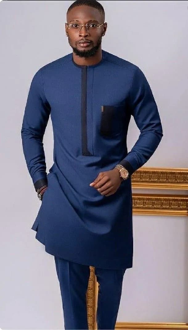 Man in a navy long-sleeve kaftan with black placket and pocket trim