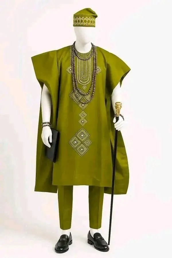 Olive agbada with geometric embroidery, matching cap, beads and trousers on a mannequin