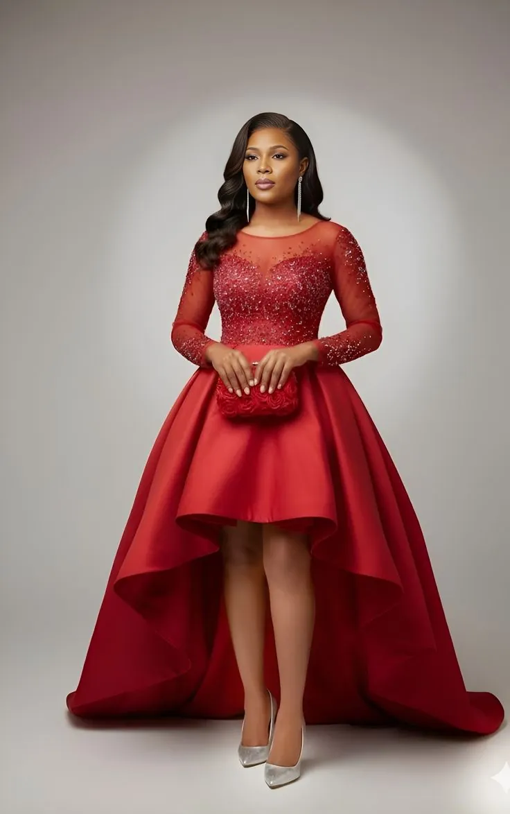 Woman in a red gown with a beaded lace bodice and long sleeves above a satin high-low skirt